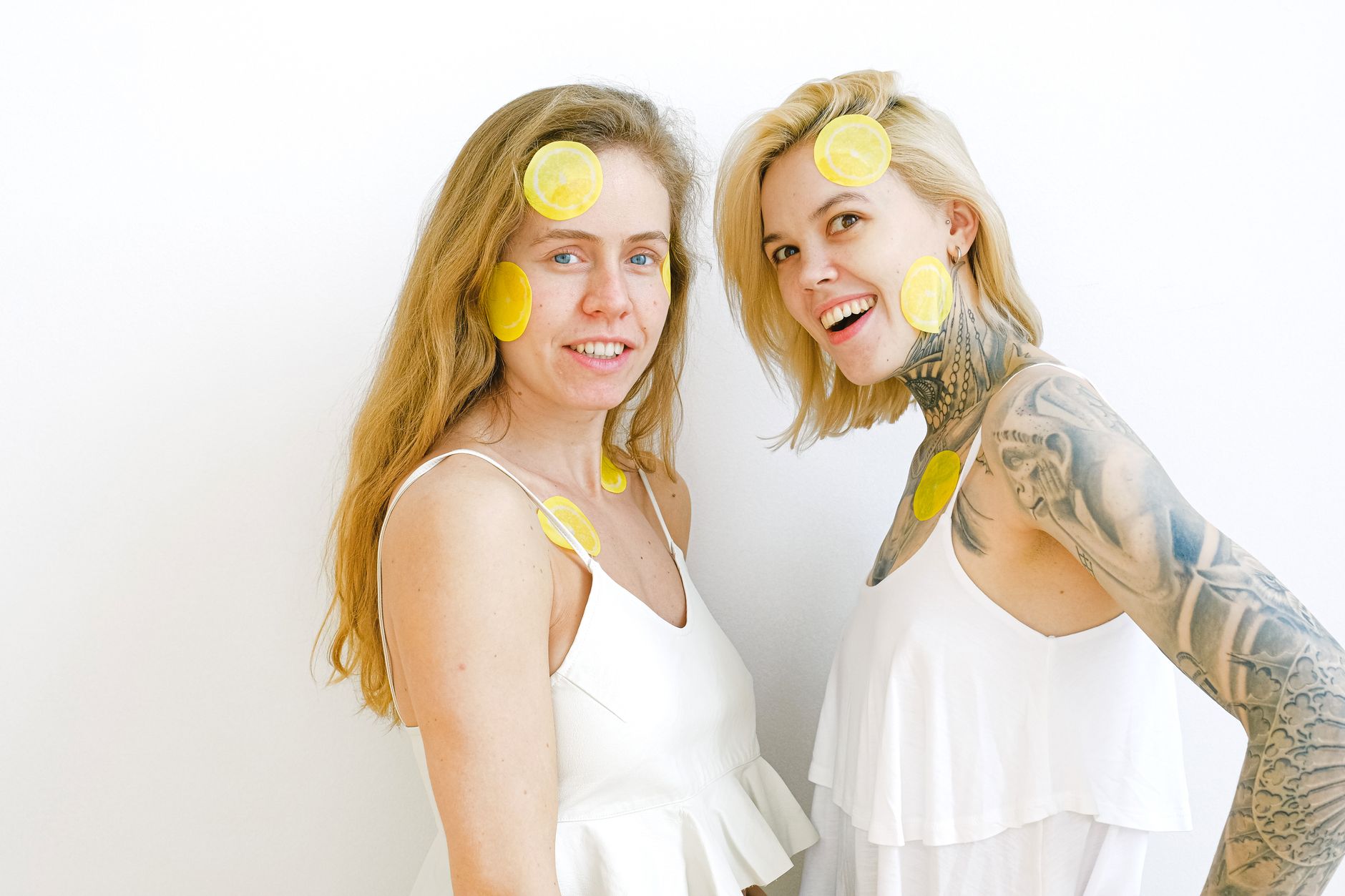Yellow silicone vibrator surrounded by fresh lemons on a bright yellow background