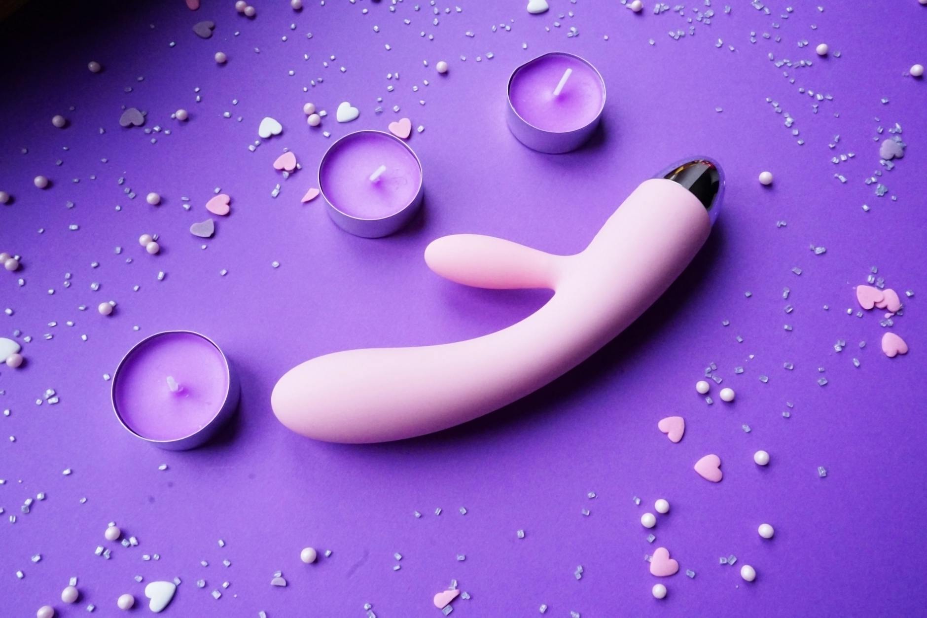 A young couple standing together indoors, holding a blue vibrator, symbolizing modern intimacy and partnership
