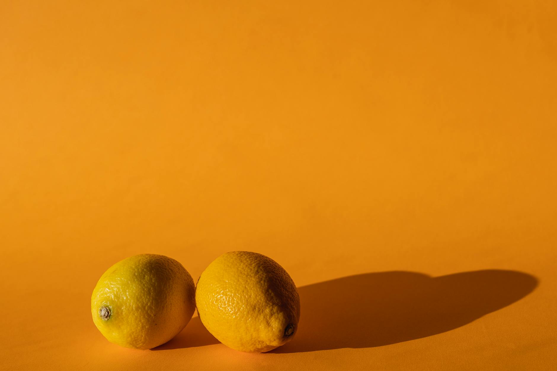 Ripe lemons on a bright yellow background, symbolizing vitality and renewal
